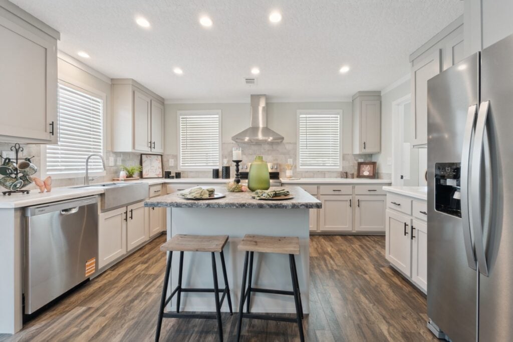 Open-concept kitchen in The LouLou with white cabinetry, a large island, and modern farmhouse design.