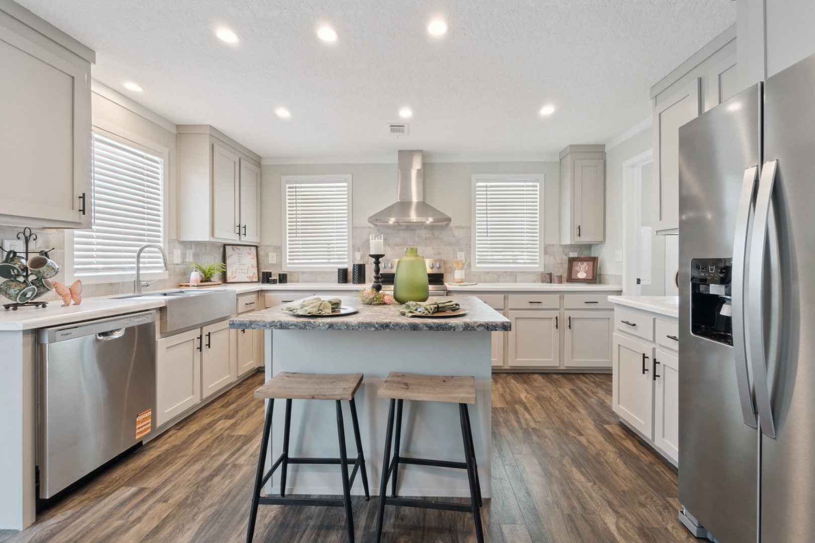 Open-concept kitchen in The LouLou with white cabinetry, a large island, and modern farmhouse design.