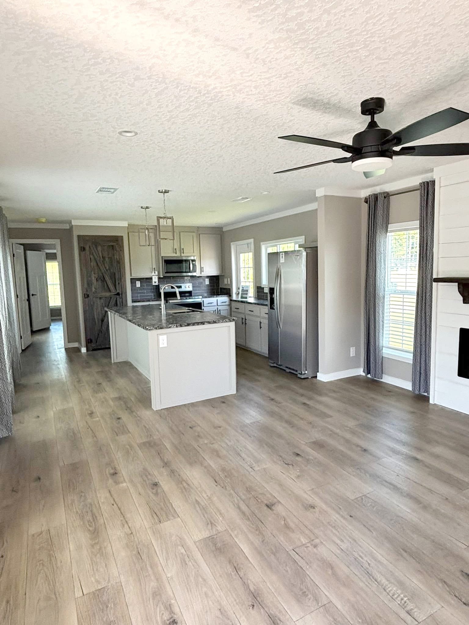 View of The Express kitchen with a center island and a stylish barn door covering the pantry.