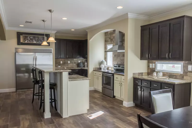 Luxurious Mediterranean style kitchen in The Cypress Manor with granite counters and rich cabinetry.